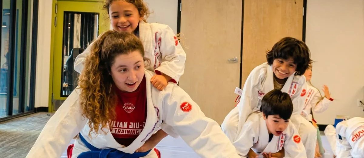 A coach and school-age kids in an AMP enrichment class